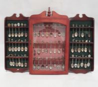 Large quantity of souvenir spoons in two display shelves and a display case and various loose spoons