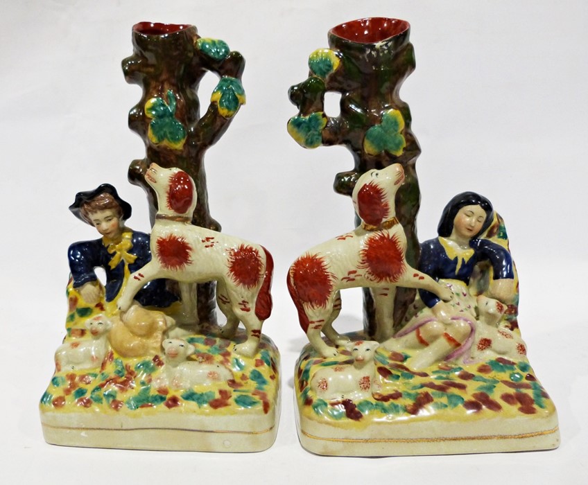 Pair of reproduction Staffordshire vases, the bases of each modelled with a seated figure surrounded