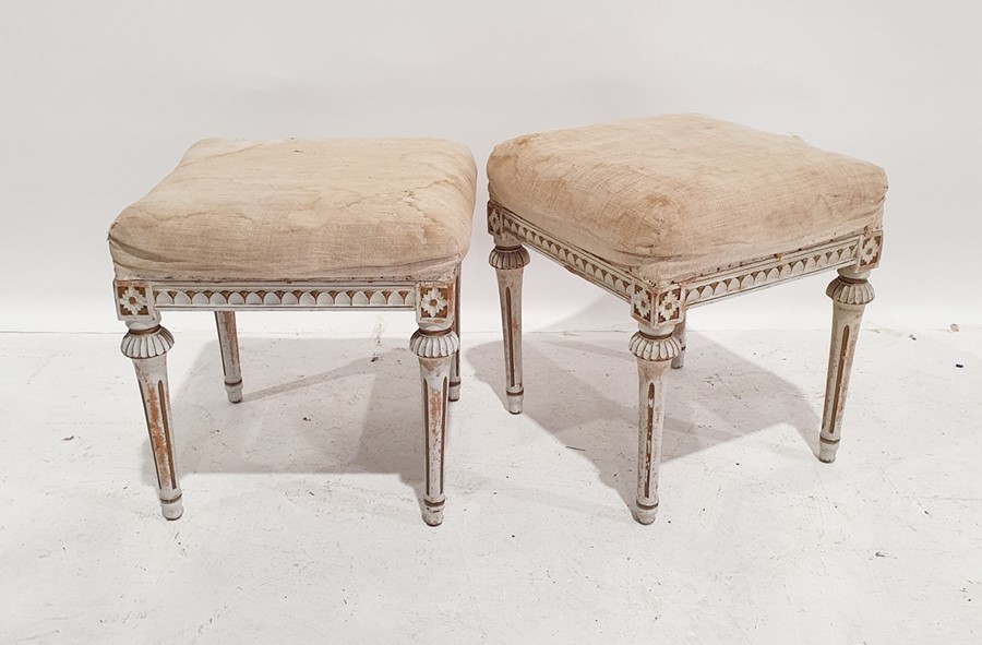 Pair of Swedish-style stools with cream upholstered overstuffed seats, on carved and fluted supports