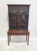 Georgian-style bookcase with ogee moulded cornice, astragal-glazed doors enclosing shelves, the base