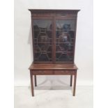 Georgian-style bookcase with ogee moulded cornice, astragal-glazed doors enclosing shelves, the base