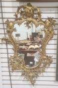 Possibly 19th century mirror, the shaped plate in gilt bronze rococo-style frame, 82cm x 49cm approx