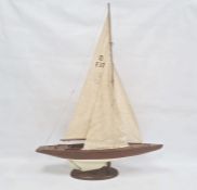 Varnished and painted wood model yacht with canvas sails and the associated wooden stand, 102cm high