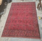 Eastern-style rug, red ground with repeating pattern decoration, stepped border, 298cm x 204cm