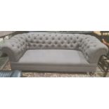 Late Victorian Chesterfield sofa in grey button back upholstery, on turned front legs to brown china