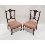Pair of Edwardian low bedroom chairs with carved and pierced backsplat, pink upholstered seat,