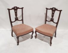 Pair of Edwardian low bedroom chairs with carved and pierced backsplat, pink upholstered seat,