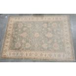 Modern pale green ground Eastern-style rug with foliate decoration to the central field, cream
