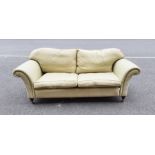 Modern three-seat sofa in pale green patterned upholstery, turned front legs to brass caps and