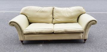 Modern three-seat sofa in pale green patterned upholstery, turned front legs to brass caps and