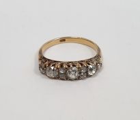 Gold carved head ring set with three graduated mixed cut diamonds interspersed by two pairs of