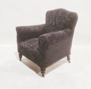 Late Victorian armchair with black loose covers, on turned front legs to brown china castors