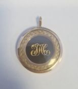 19th century gold-coloured memorial pendant of circular form with gilt metal initials surrounded