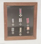 A cased set of seven medal miniatures, to include Navy long service miniature, in glazed and