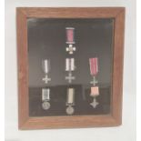 A cased set of seven medal miniatures, to include Navy long service miniature, in glazed and