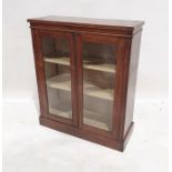 Walnut display cabinet with rectangular top, two glazed doors enclosing shelves, on plinth base,