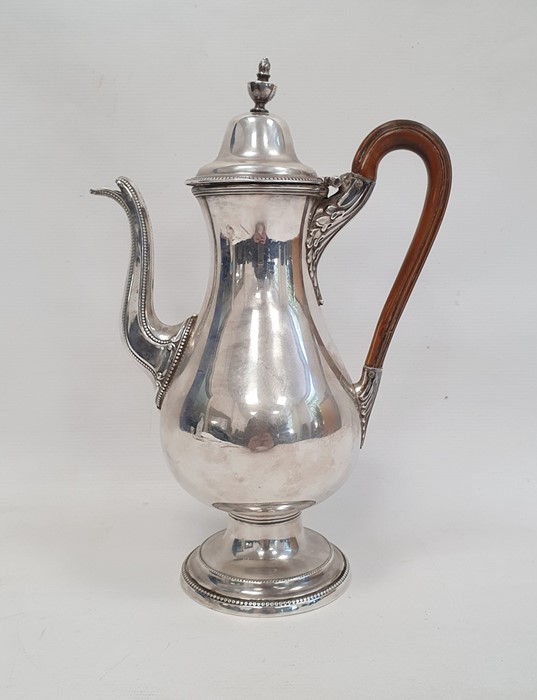 A silver plated coffee pot, wooden handle on a circular base, unmarked, etched V EL to base, 29cm