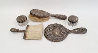 Silver-coloured dressing table mirror and matching brush profusely decorated with flowers, marked