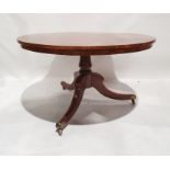 19th century snap-top circular table with figured top, turned column, on three ogee legs, brass caps