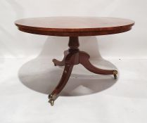 19th century snap-top circular table with figured top, turned column, on three ogee legs, brass caps