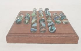 A 20th century marble solitaire board, square shaped with thirty two marbles