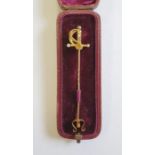 Gold-coloured stickpin modelled as a sword with seedpearl and diamond set hilt, in fitted case