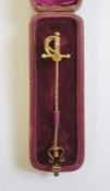 Gold-coloured stickpin modelled as a sword with seedpearl and diamond set hilt, in fitted case