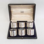 A cased set of six George V silver napkin rings, plain form, initialed 'AMR', London 1918, maker