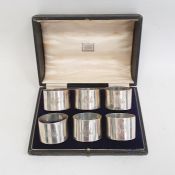 A cased set of six George V silver napkin rings, plain form, initialed 'AMR', London 1918, maker