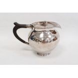 Silver covered jug by A E Jones, London 1911 of circular form with hammered finish, the hinged cover
