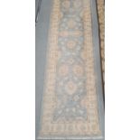 Modern Eastern-style duck egg blue ground foliate decorated rug with stepped border, 306cm x 79cm