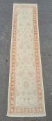 Modern Eastern-style cream ground runner with foliate decoration, peach ground borders, 296cm x 75cm