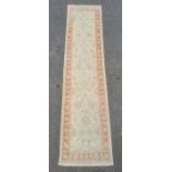 Modern Eastern-style cream ground runner with foliate decoration, peach ground borders, 296cm x 75cm