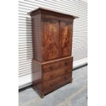 19th century mahogany linen press, the cornice above two doors enclosing linen shelves, the base