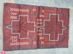 Eastern rug, red ground with two central medallions in reds, blacks, oranges and creams, 130 x 85cm