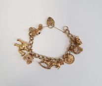 Gold-coloured curb link bracelet hung with assorted gold-coloured charms, some hallmarked 9ct, total