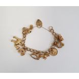 Gold-coloured curb link bracelet hung with assorted gold-coloured charms, some hallmarked 9ct, total