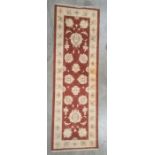 Modern Eastern-style red ground runner, foliate decorated with cream ground border, 180cm x 58cm