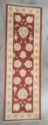 Modern Eastern-style red ground runner, foliate decorated with cream ground border, 180cm x 58cm