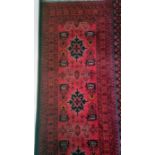 Modern Eastern-style runner with red ground, field with assorted motifs, stepped border, 83cm x