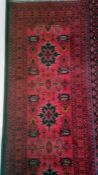 Modern Eastern-style runner with red ground, field with assorted motifs, stepped border, 83cm x