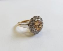 18ct gold, champagne topaz and diamond cluster ring, the centre oval mixed cut topaz surrounded by