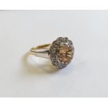 18ct gold, champagne topaz and diamond cluster ring, the centre oval mixed cut topaz surrounded by