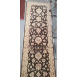 Modern Eastern-style brown ground rug with cream foliate decoration, 306cm x 84cm