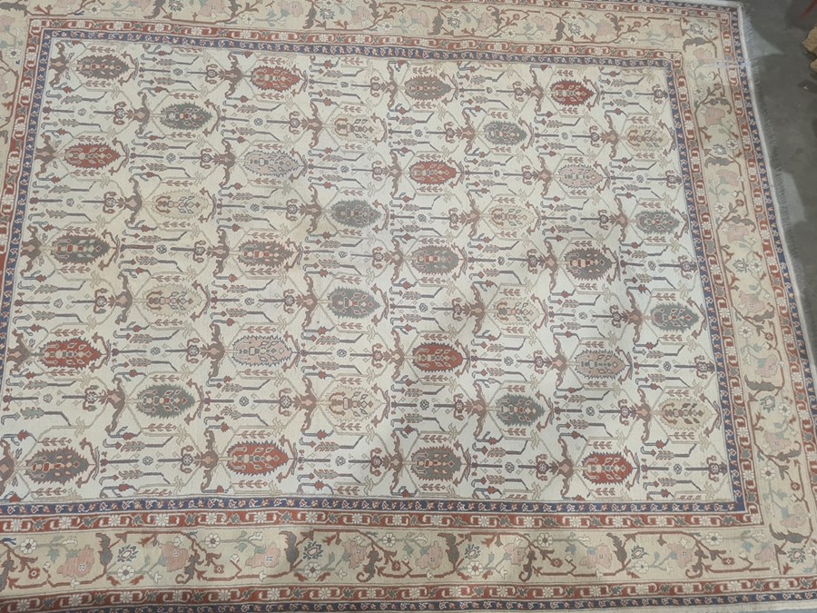 Large modern cream ground rug with allover decoration of various hooked medallions, etc, stepped