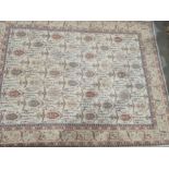 Large modern cream ground rug with allover decoration of various hooked medallions, etc, stepped