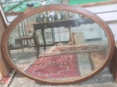 Late 19th/early 20th century oval mirror in rosewood-effect frame, 107cm x 85cm