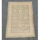 Pale green ground modern Eastern-style rug with foliate decoration to the central field, cream