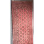Modern red ground runner with repeating elephant foot gul pattern, stepped border in reds, blacks
