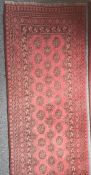 Modern red ground runner with repeating elephant foot gul pattern, stepped border in reds, blacks